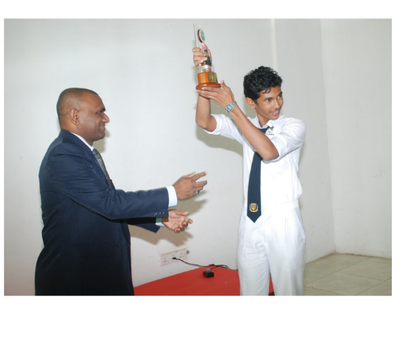 A student receiving a debate trophy